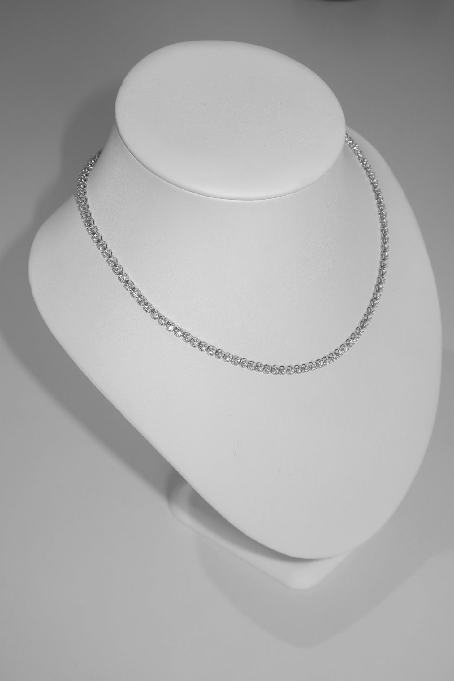 Elegant diamond necklace displayed on a white bust, showcasing its delicate sparkle and luxury appeal. Perfect for high-end jewellery lovers.