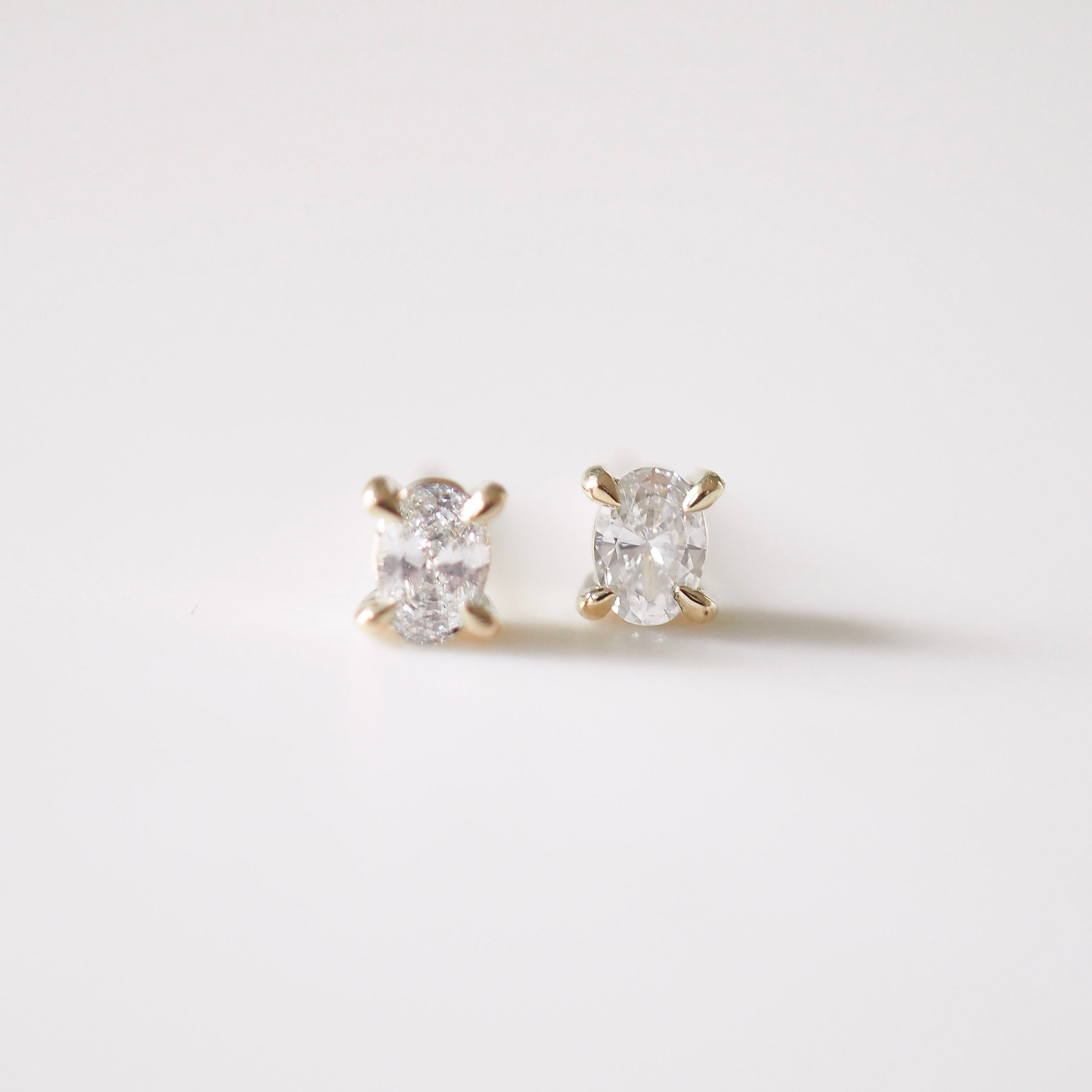 Pair of diamond stud earrings on a light gray background