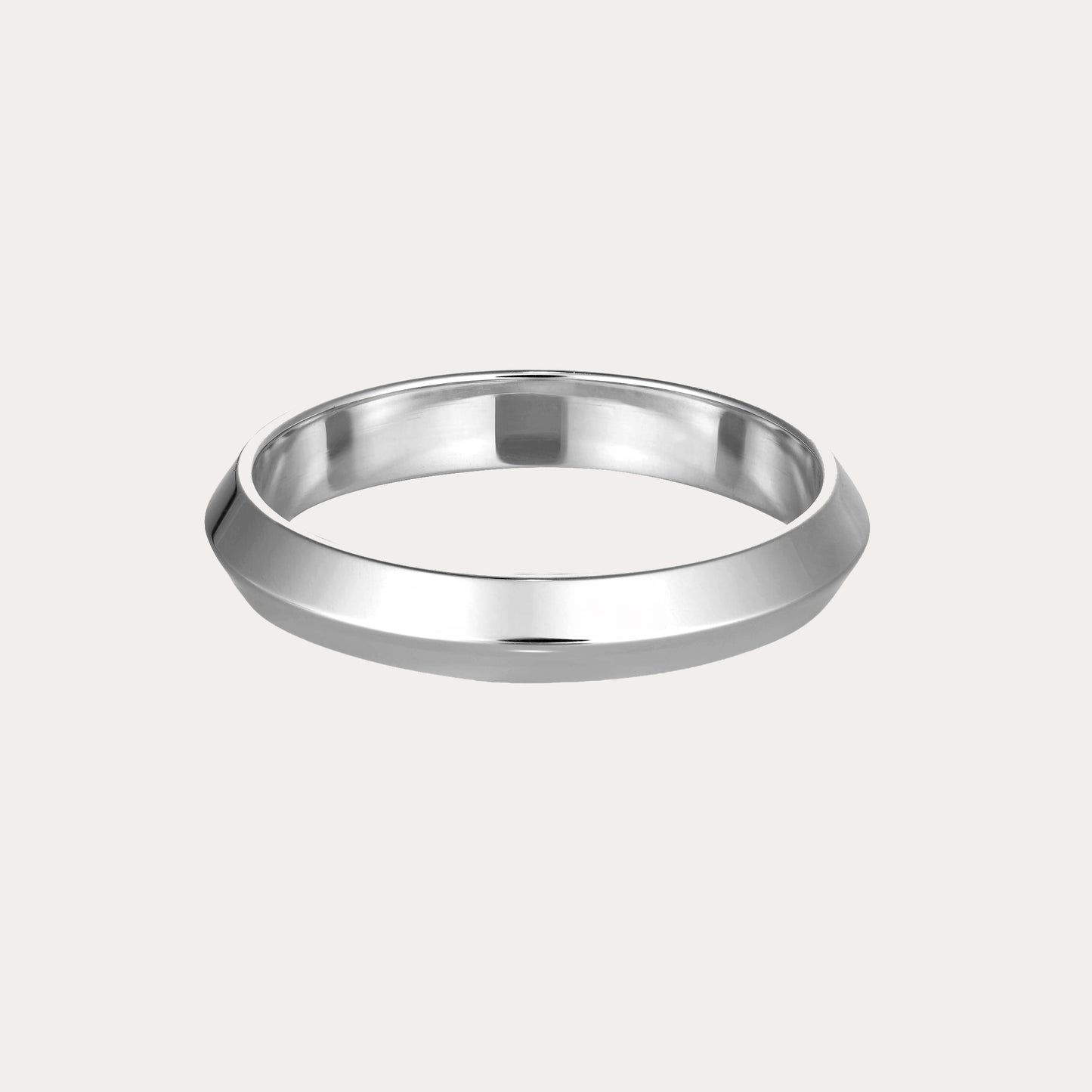 Sleek silver bangle with a geometric design, showcasing minimalist elegance against a pale background, epitomising luxury jewellery.