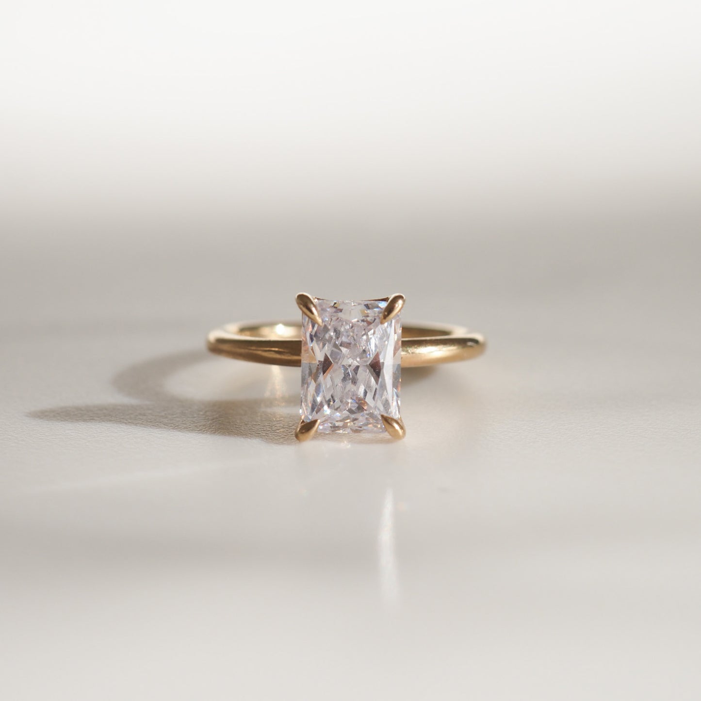 Gold ring with a radiant-cut diamond solitaire, showcasing elegant simplicity in luxury jewellery.