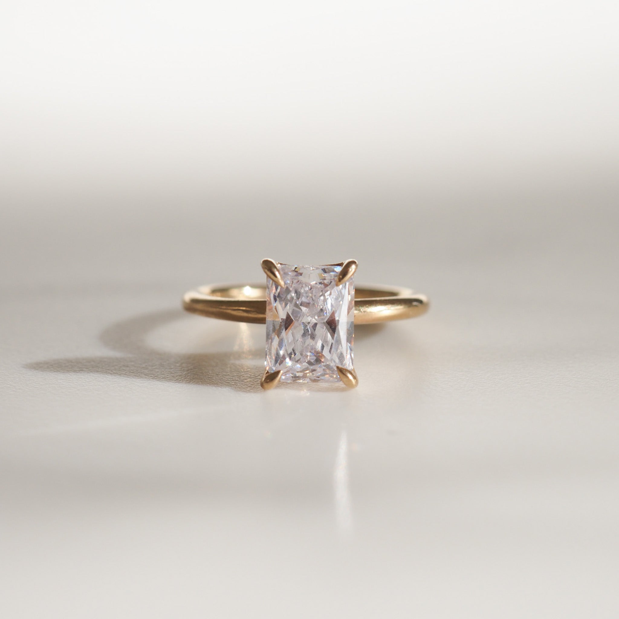 Gold ring with a radiant-cut diamond solitaire, showcasing elegant simplicity in luxury jewellery.