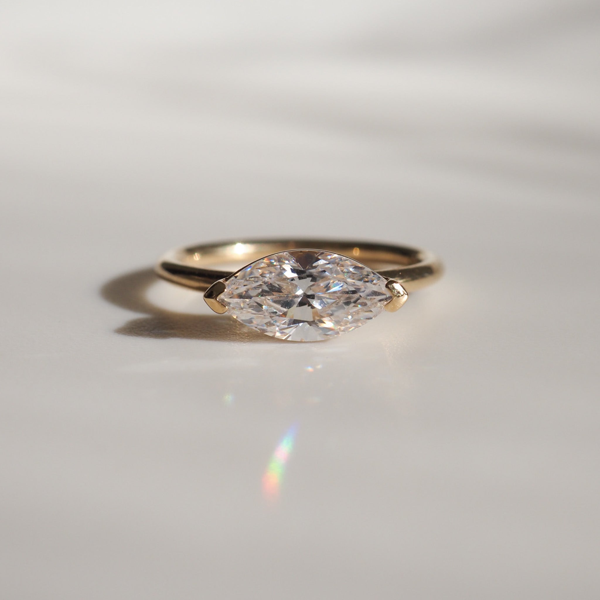 Gold ring featuring a marquise-cut diamond, sparkling on a light background. Perfect piece for luxury jewellery enthusiasts.