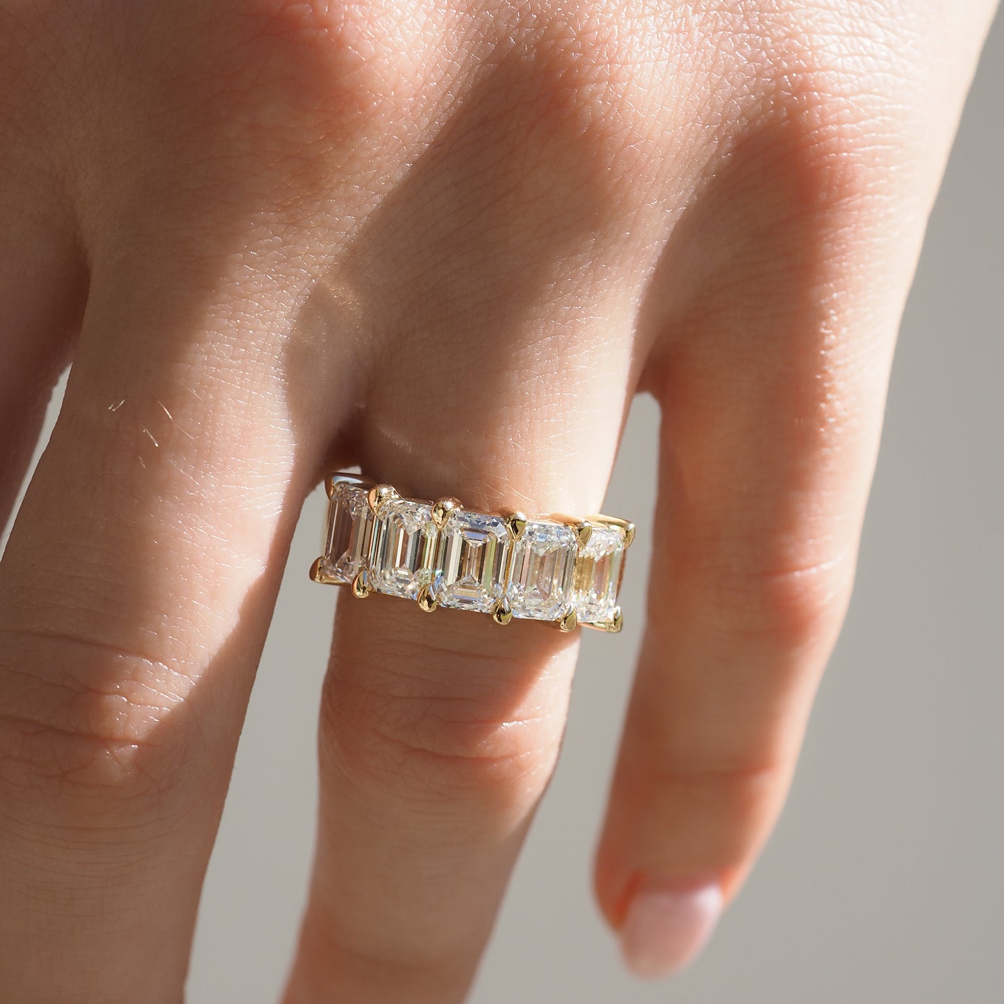 Gold ring with large rectangular diamonds on a hand, showcasing elegant luxury jewellery. Perfect for high-end fashion and style enthusiasts.