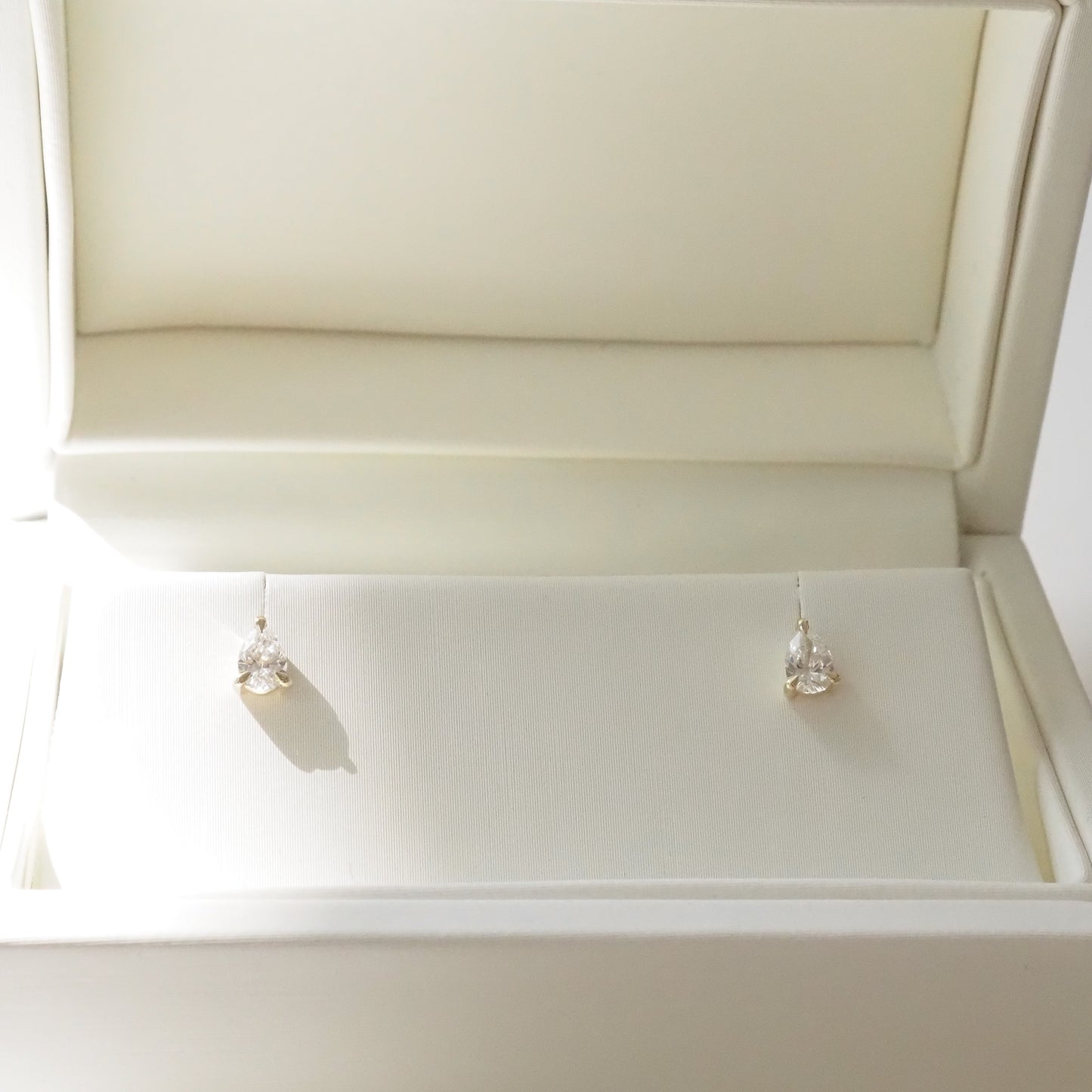 Pair of pear diamond earrings in a white jewelry box