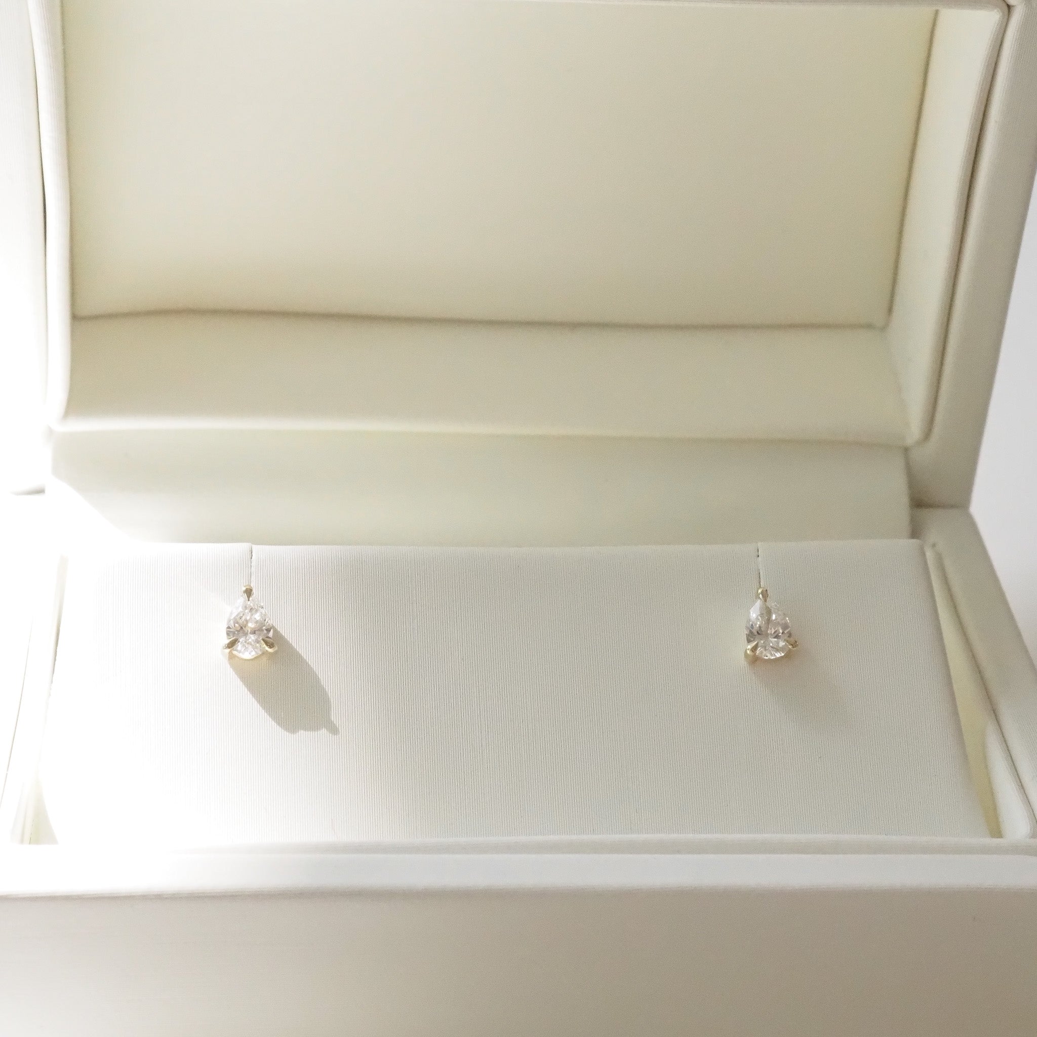 Pair of pear diamond earrings in a white jewelry box