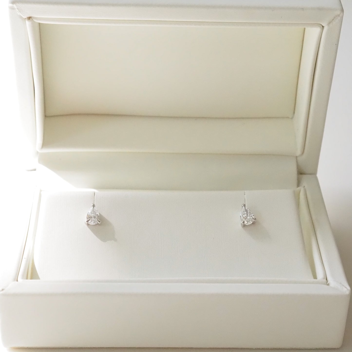 Pair of pear diamond earrings in a white jewelry box