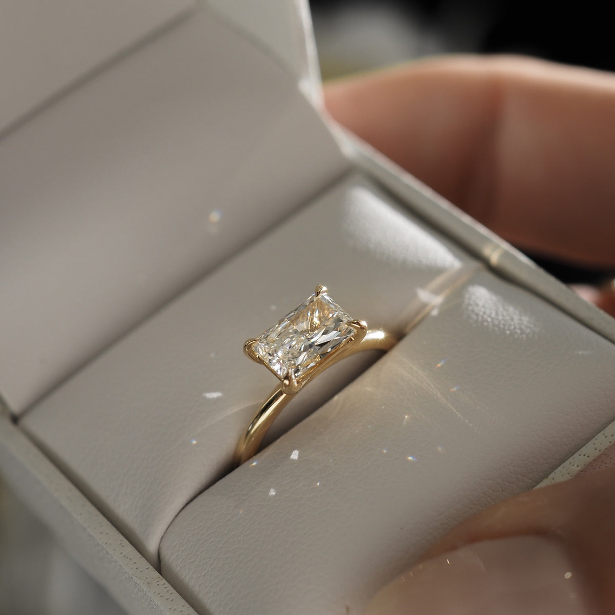Rai celebrates the elongated facets of a adiant cut lab-grown diamond, held within a contemporary east-west setting, solid 18ct yellow gold.
