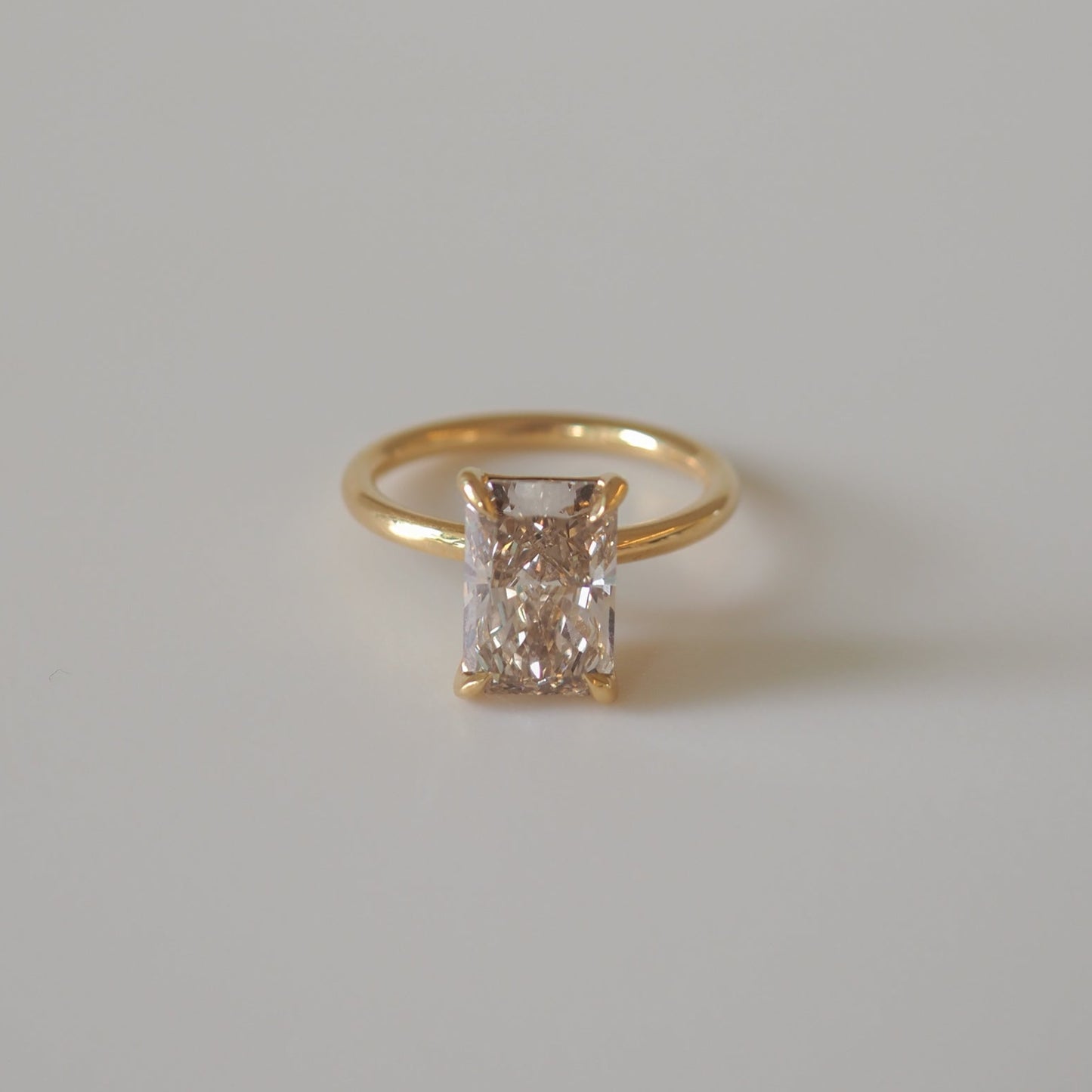 Rectangular diamond ring with gold band against plain background. Luxury jewellery, elegant design, perfect for engagement or special occasions.