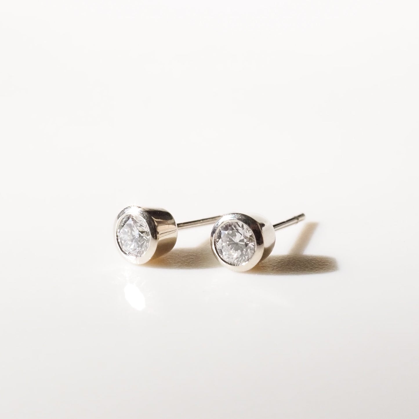 Pair of silver stud earrings with clear gemstones on a white background