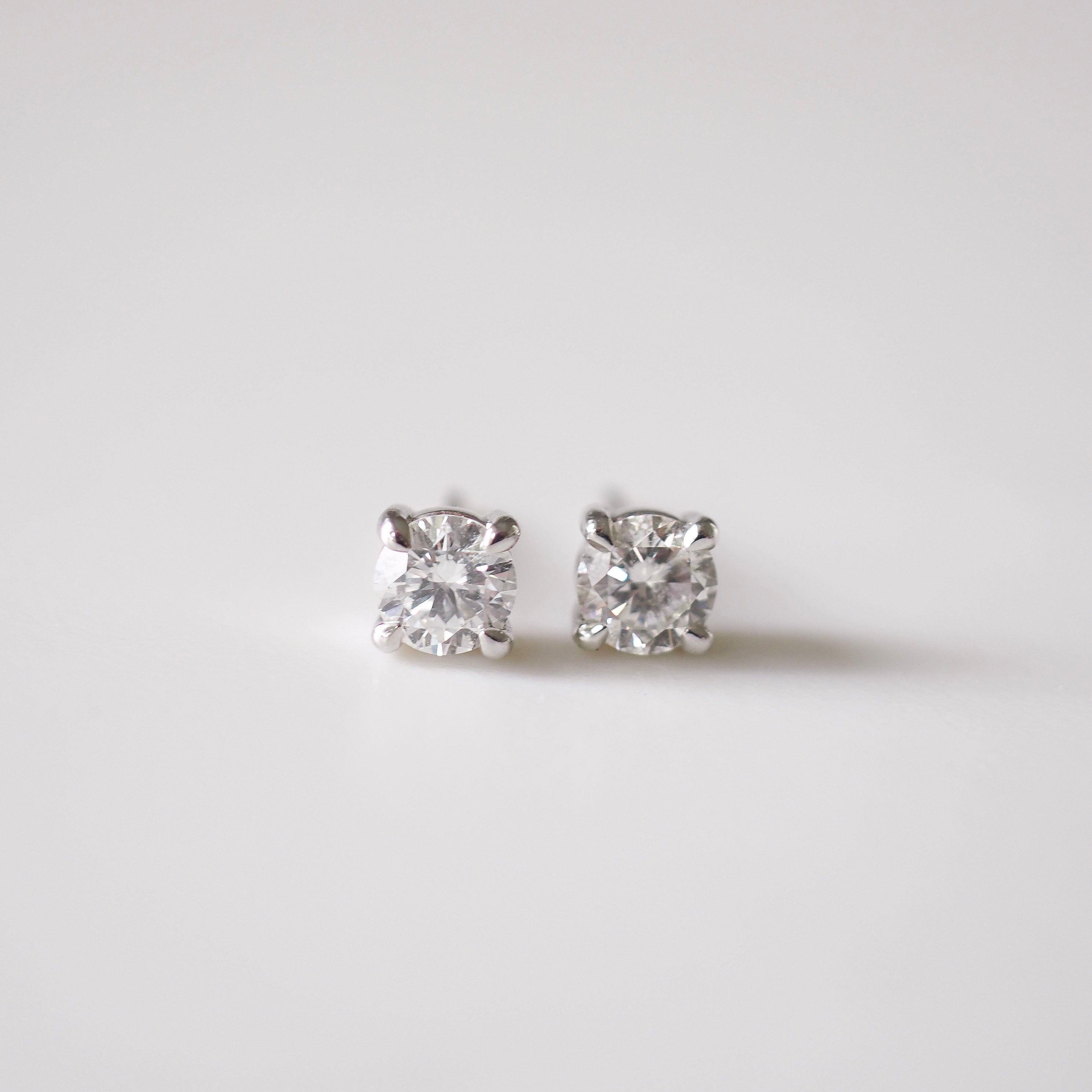Pair of diamond stud earrings on a light gray background