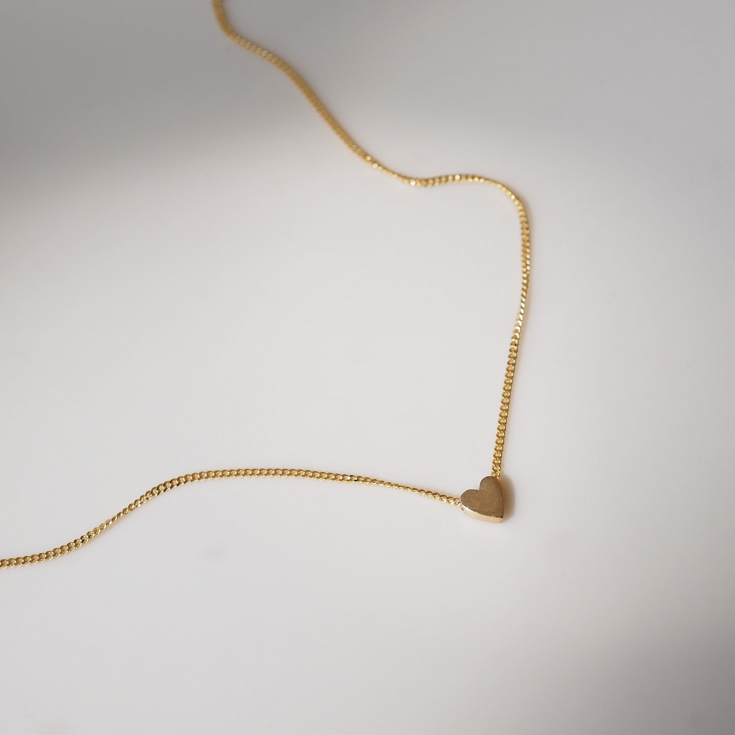 Small heart charm on yellow gold chain