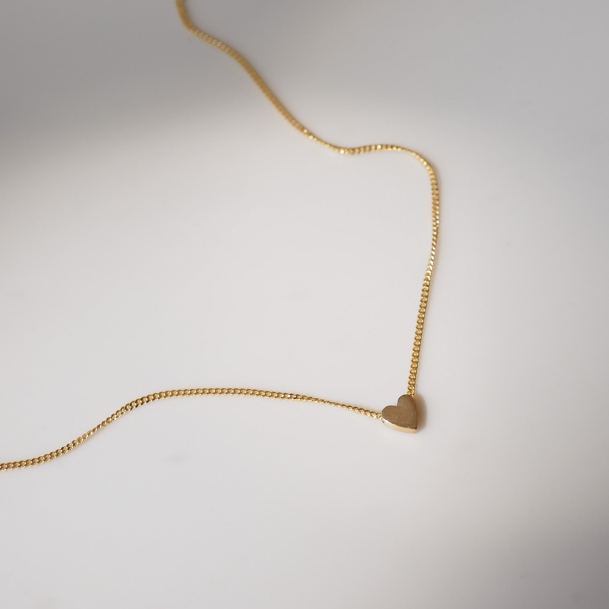 Small heart charm on yellow gold chain