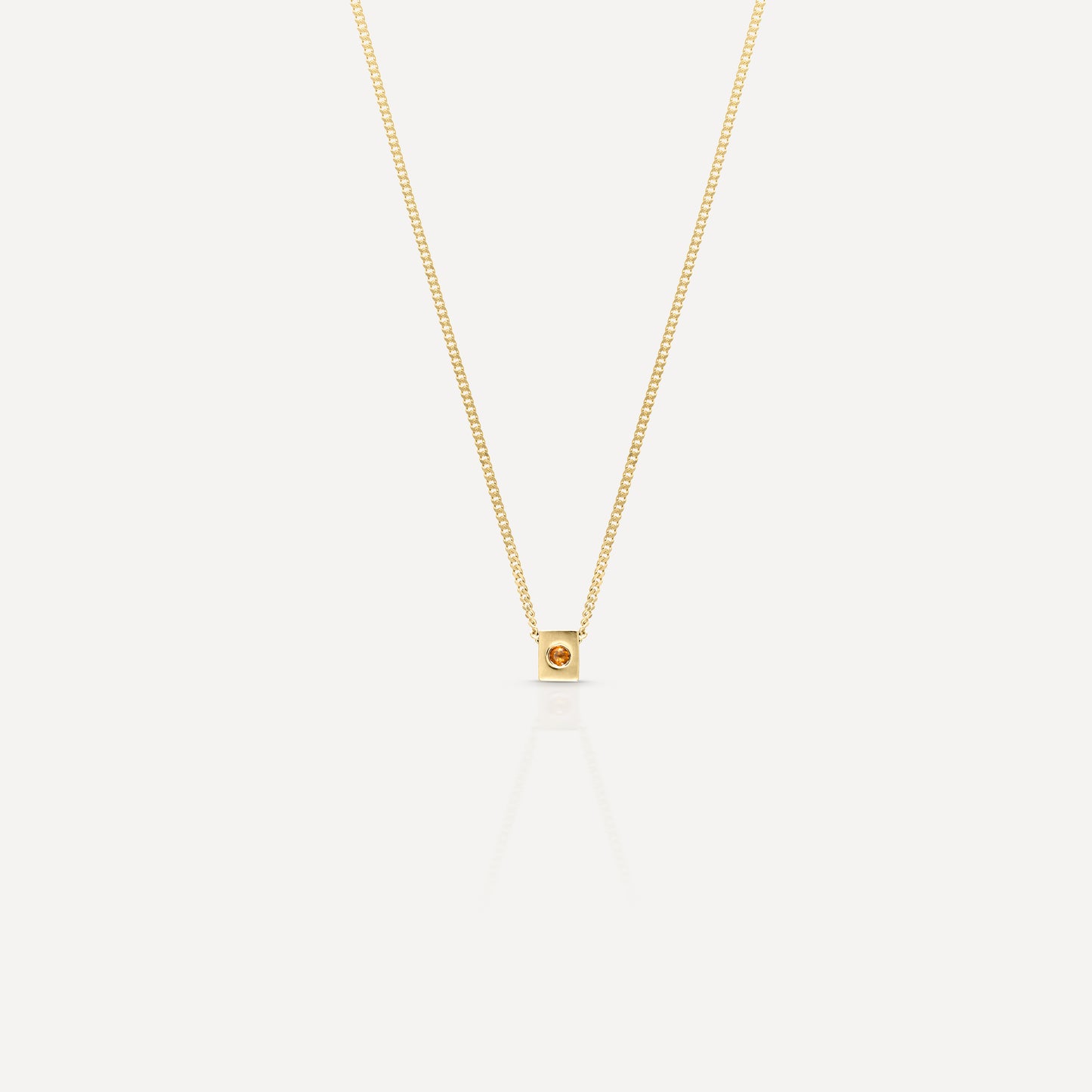 Gold necklace with a delicate chain, featuring a small square pendant set with a single orange gemstone. Luxurious and elegant jewellery piece.