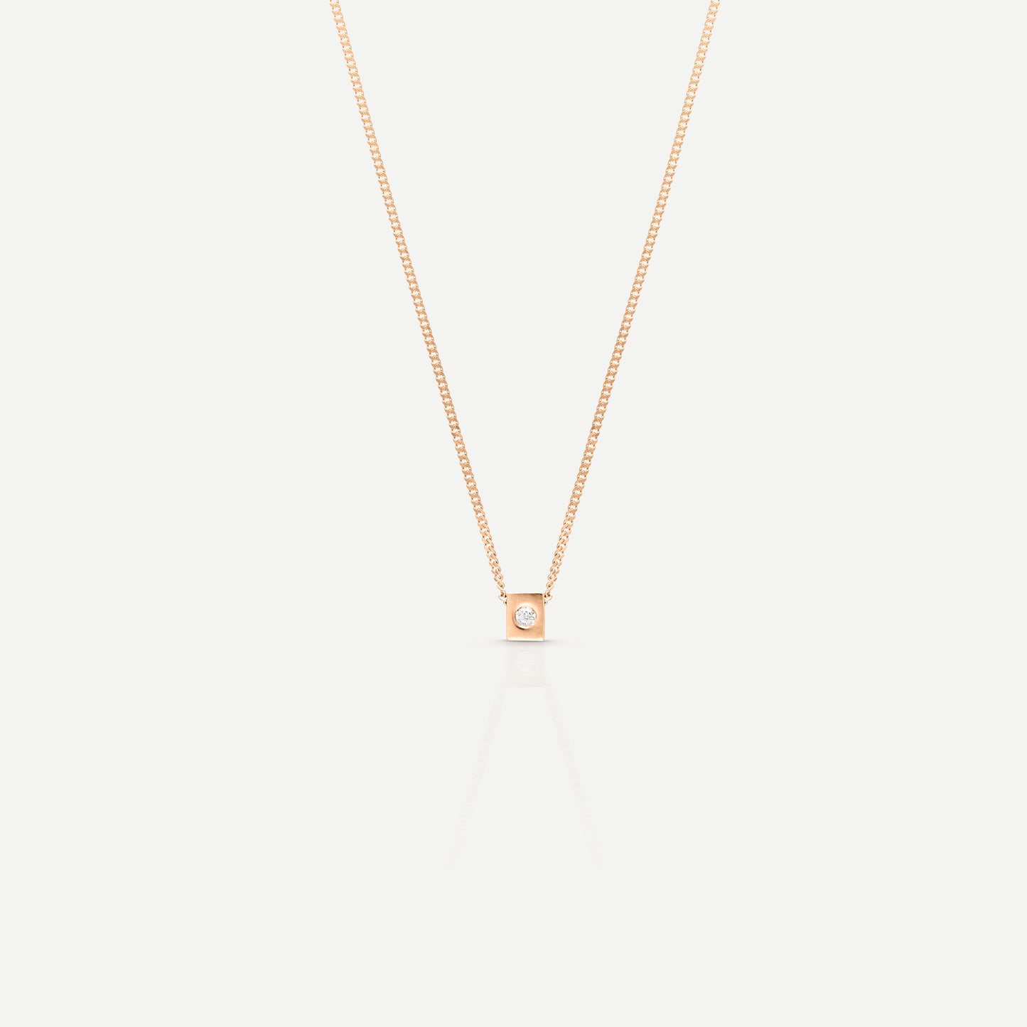 Elegant rose gold necklace with a single diamond pendant on a light background, showcasing minimalist luxury jewellery design.