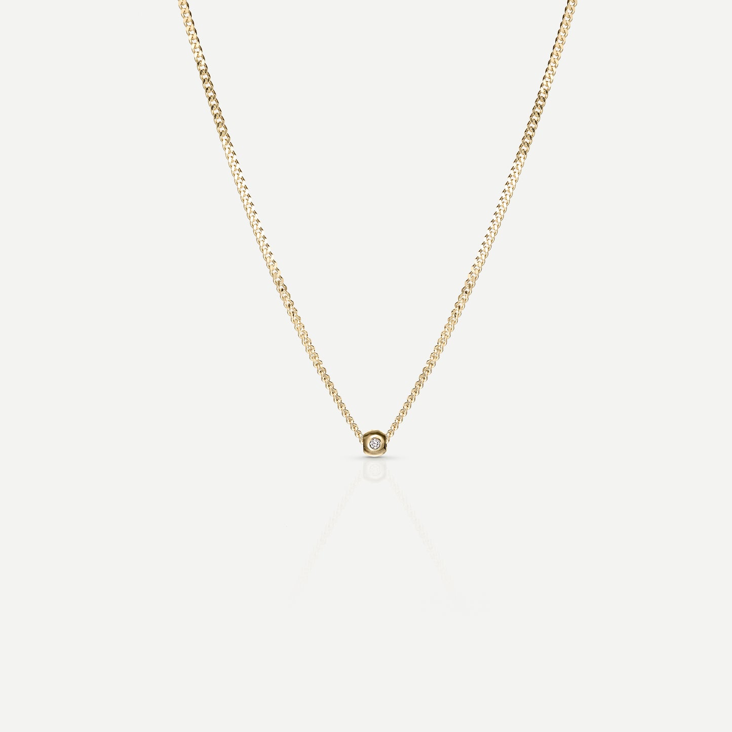 Elegant gold chain necklace with a small diamond pendant centered, displayed on a light background, epitomising luxury jewellery design.
