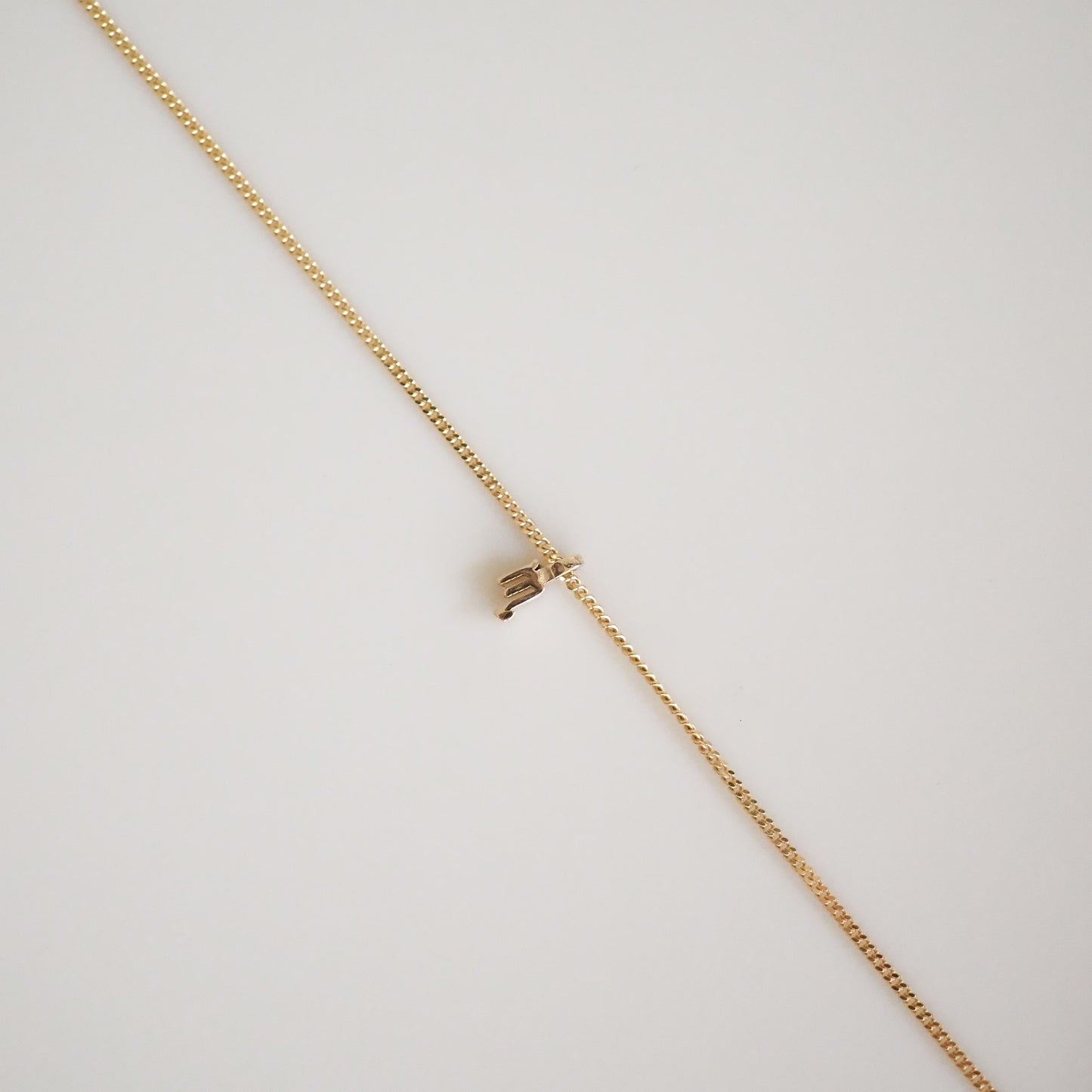 Delicate gold chain necklace with a minimal clasp, displayed on a light background; ideal for luxury jewellery enthusiasts.