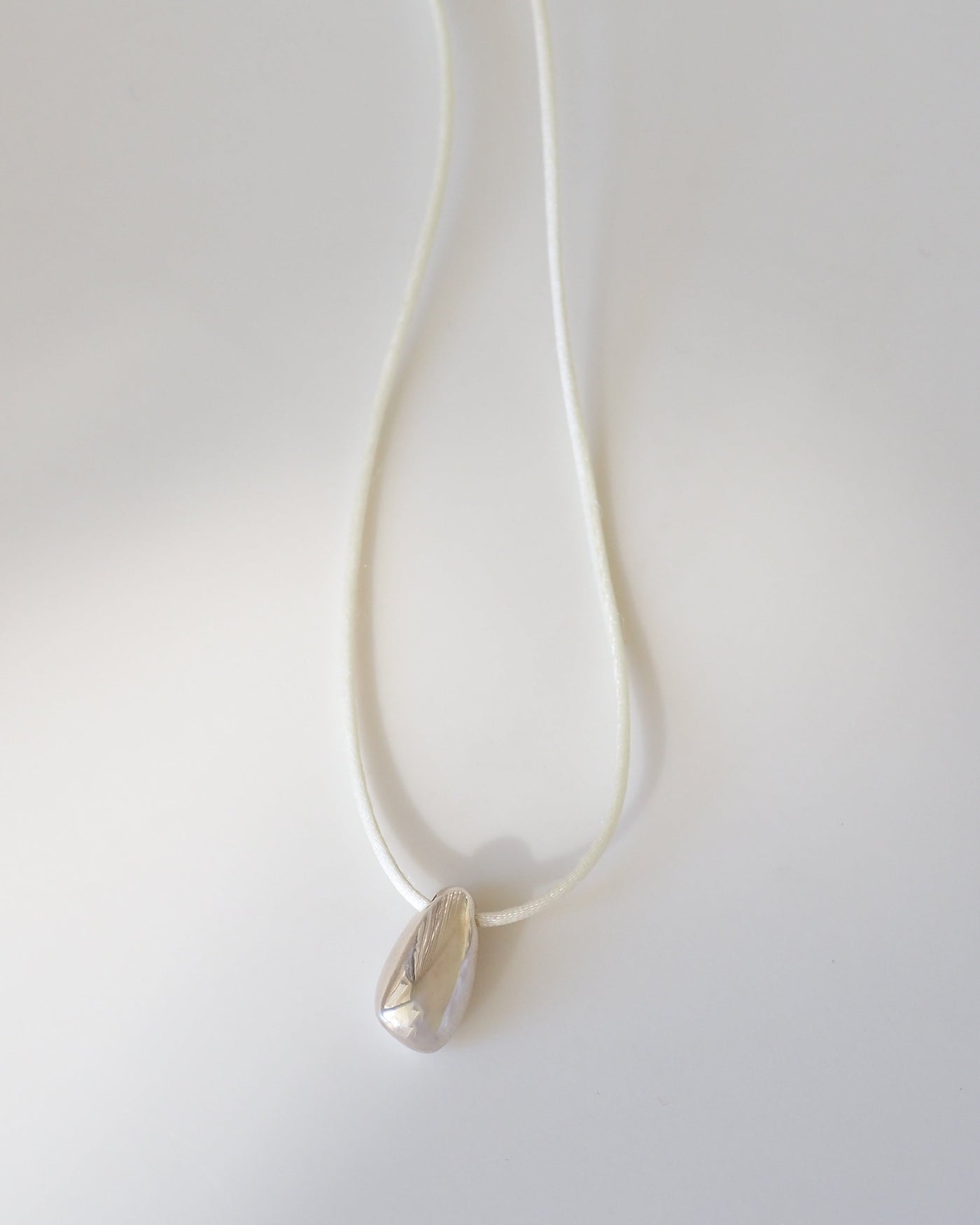 Silver necklace with a pendant on a white background