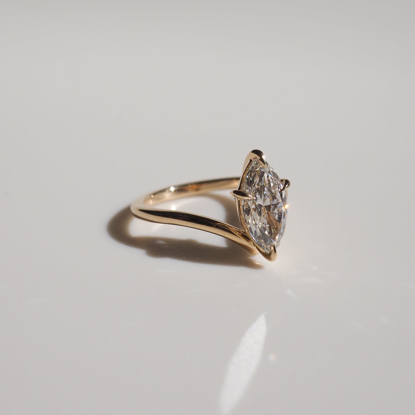 Gold ring featuring a marquise-cut diamond, elegantly styled on a reflective surface. Perfect for luxury jewellery enthusiasts.