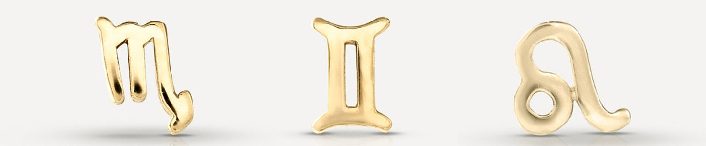 Gold zodiac pendants featuring Scorpio, Gemini, and Leo symbols, elegantly crafted and polished, on a subtle light background.