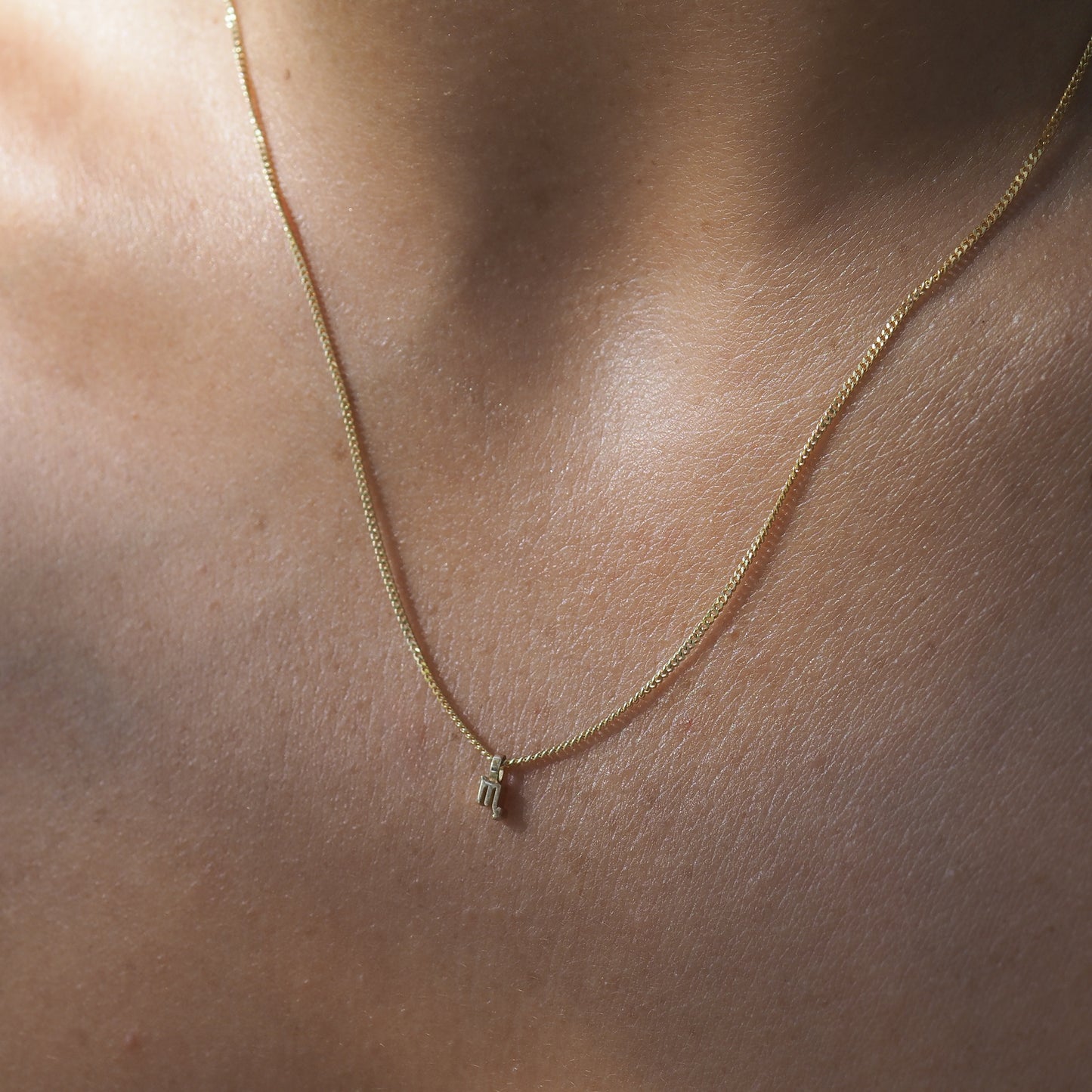 The Scorpio Zodiac Necklace highlights the Scorpio symbol among a yellow gold chain.