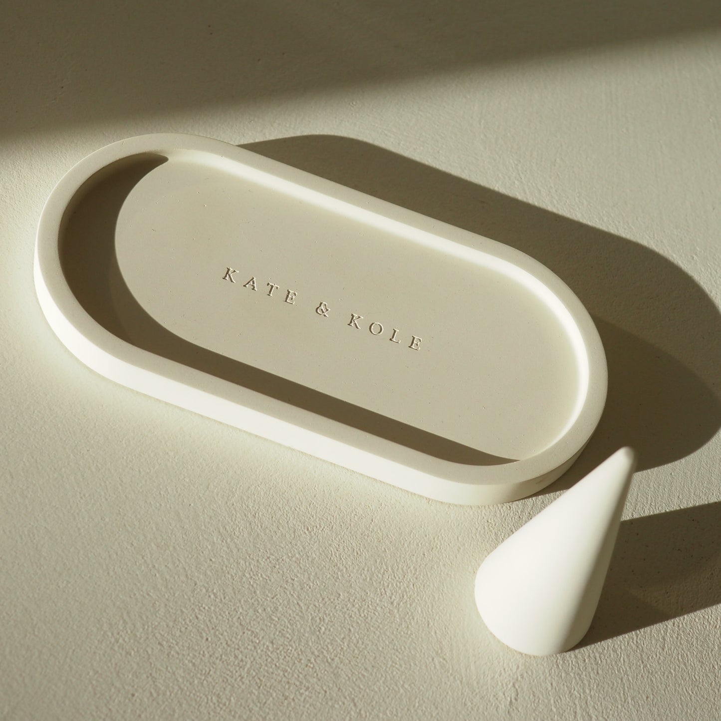 Beige ceramic tray with 'KATE & KOLE' branding on a beige background