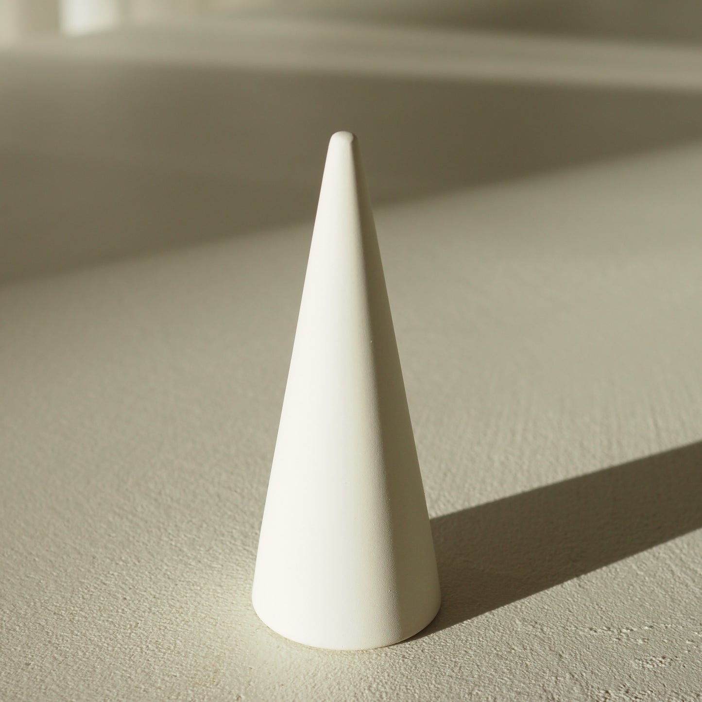 White ring sizer on a textured beige surface