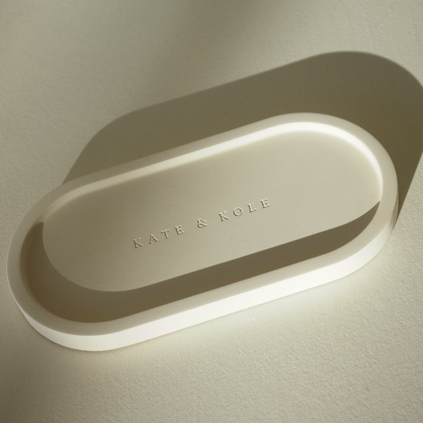 Oval-shaped tray with 'KATE & KOLE' branding on a light background