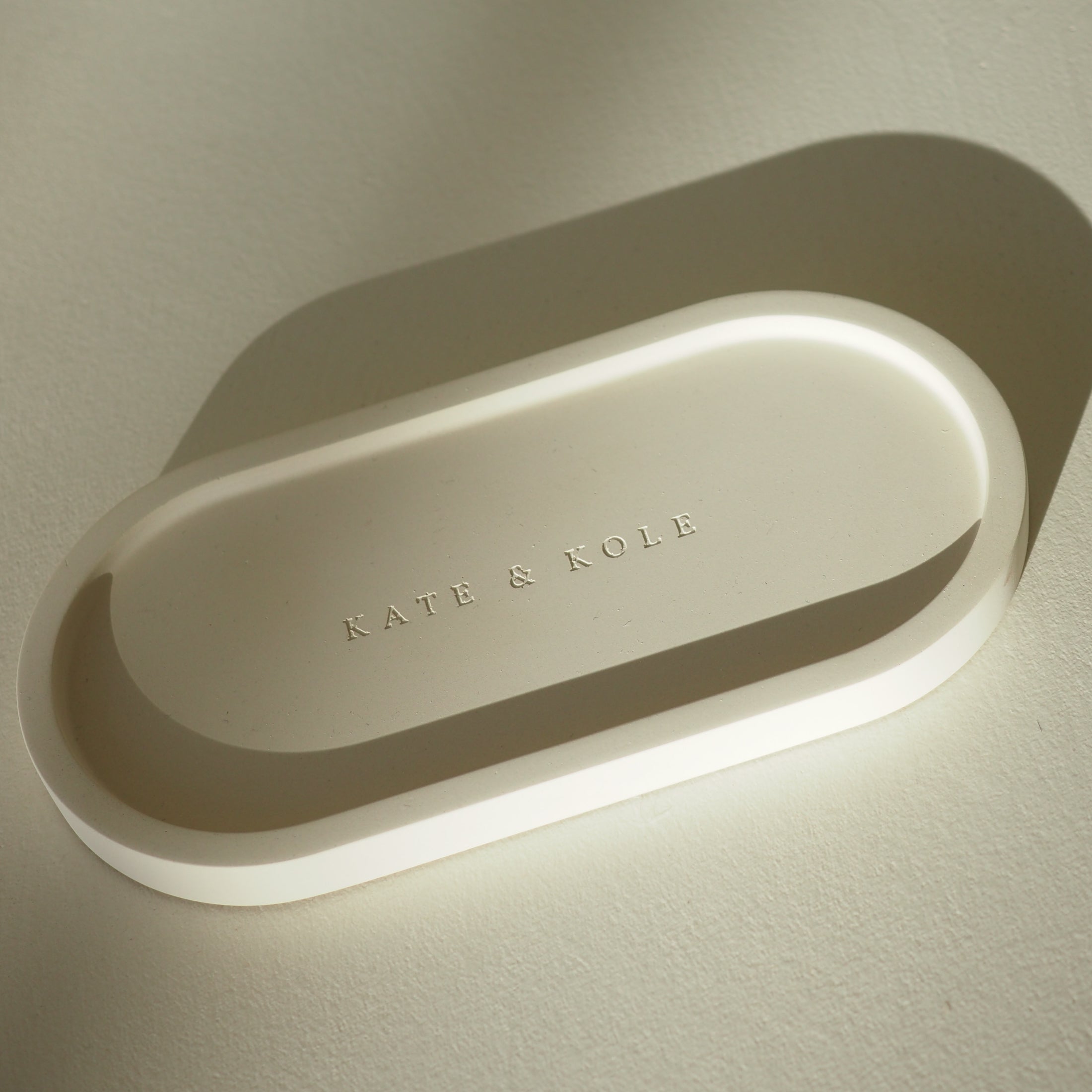 Oval-shaped tray with 'KATE & KOLE' branding on a light background