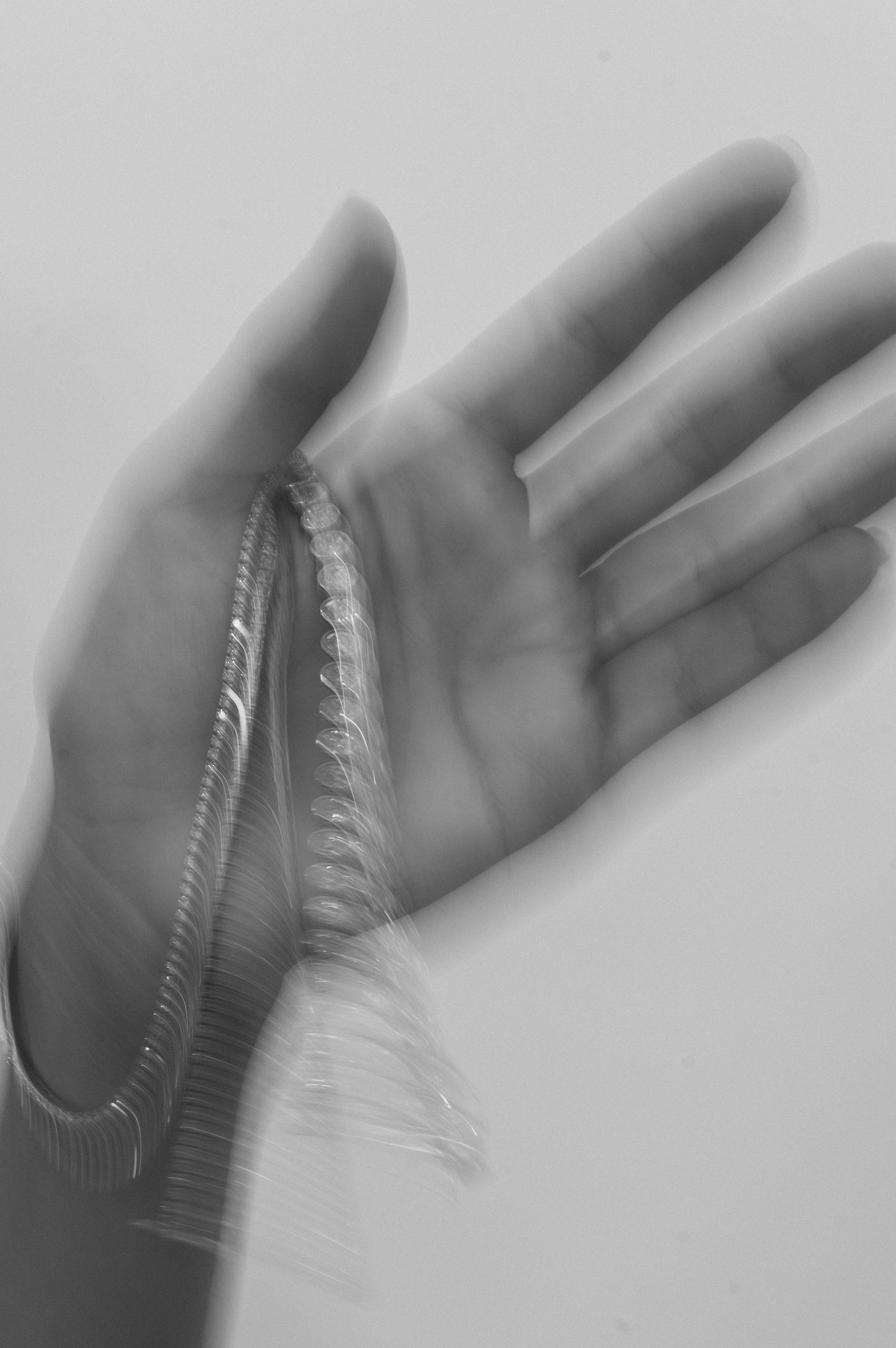 Blurred monochrome image of an open hand gently holding a shimmering, intricate chain, evoking luxury and elegance.