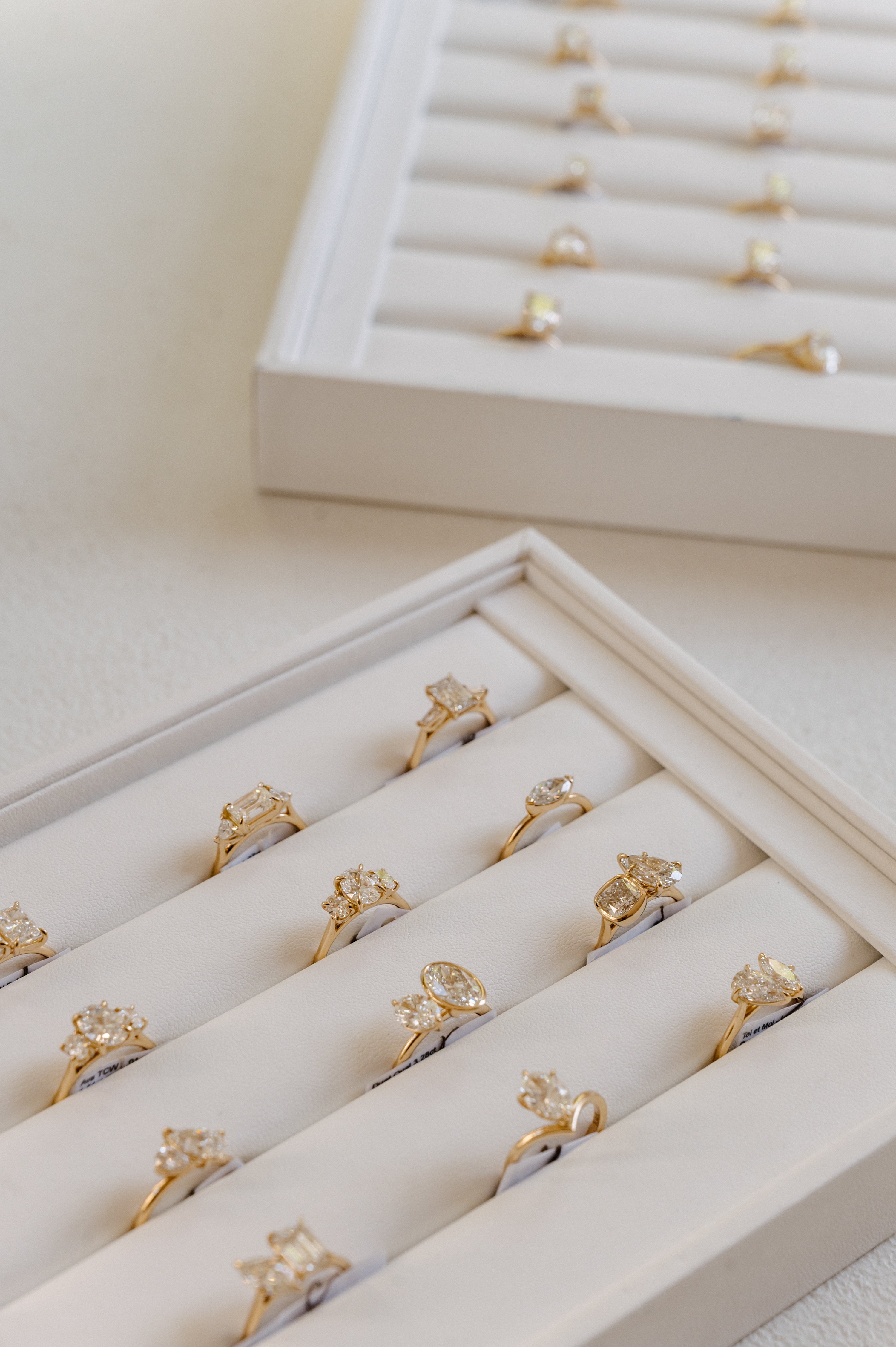 Luxury jewellery display featuring gold rings with diamonds set in elegant boxes on a white surface. Perfect for high-end style seekers.