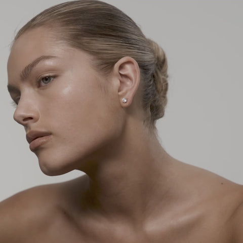Woman wearing round diamond studs
