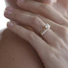 Arraya diamond set band on models hand featuring our Cleo lab grown diamond engagement ring 