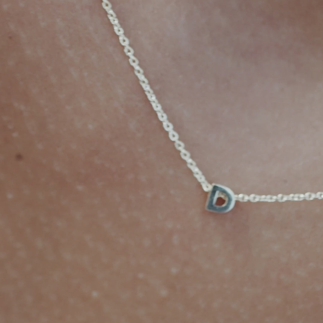 Solid gold and sterling silver jewellery: Video of a model wearing our signature sterling silver tiny letter D charm necklace on a 40cm cable chain