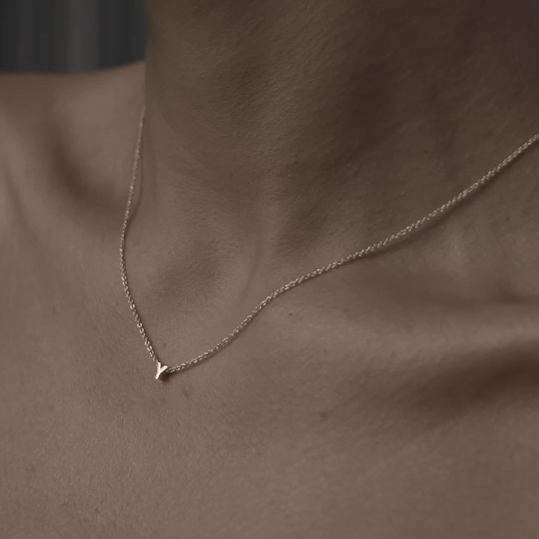 Solid gold and sterling silver jewellery: Close up video of a model wearing our signature 9ct yellow gold Tiny Letter Y Charm Necklace on a 40cm cable chain