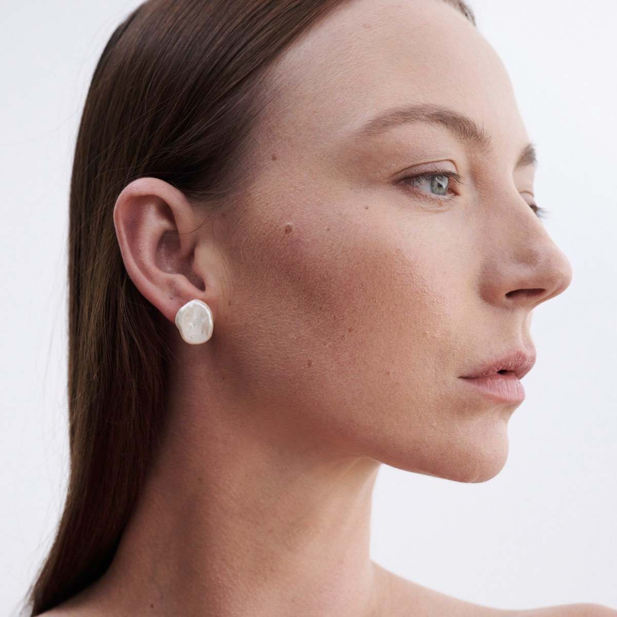 Side profile of model wearing our beautiful large baroque pearl studs in 9ct yellow gold.