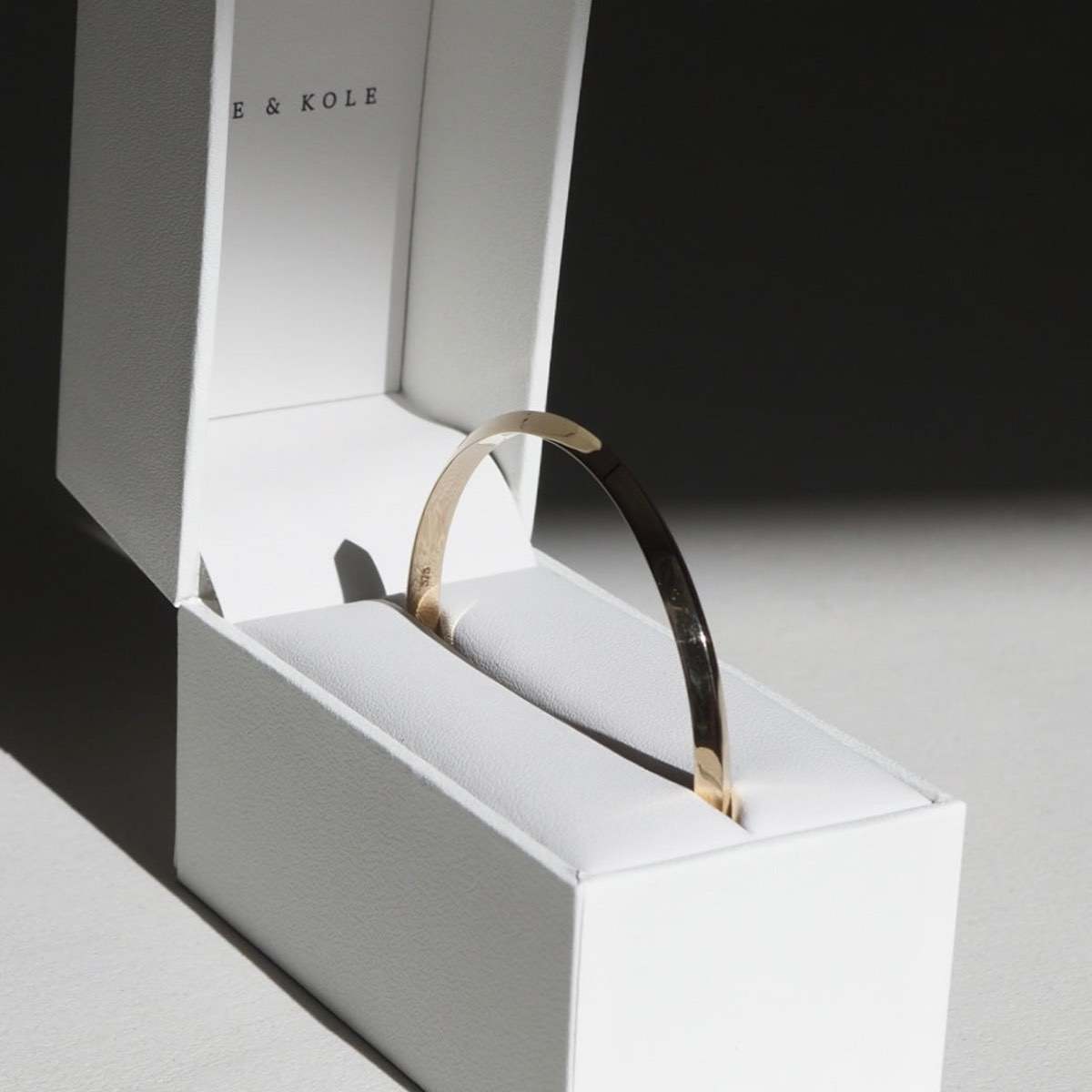 A 5mm 9ct yellow gold solid knife edge bangle sitting perfectly in our Kate & Kole jewellery box