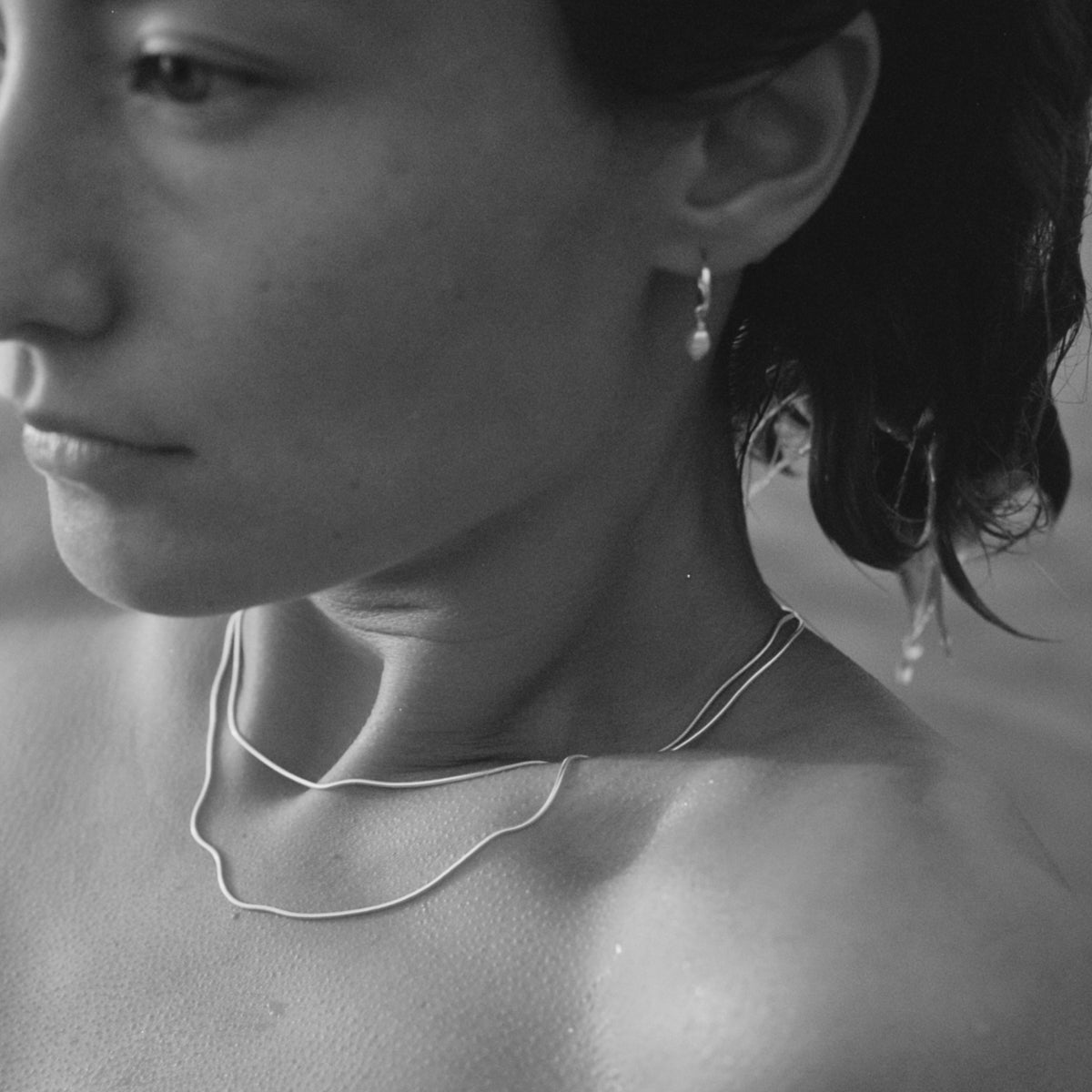 Model swimming whilst layering two solid silver snake chains in 40cm and 45cm lengths. Matched effortlessly with our tiny baroque pearl earrings.